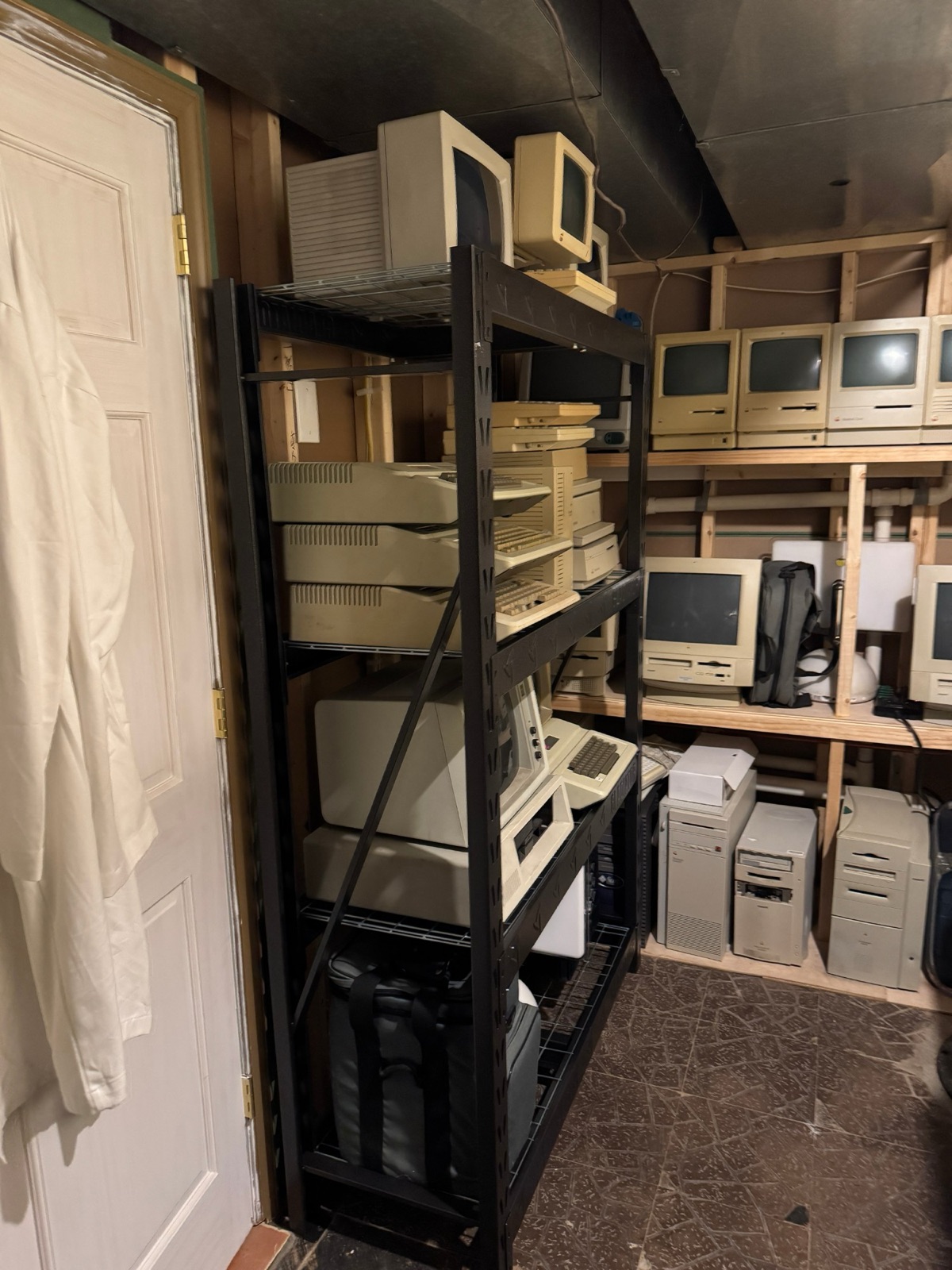 Metal shelving with Apple II-era computers, monitors, and keyboards