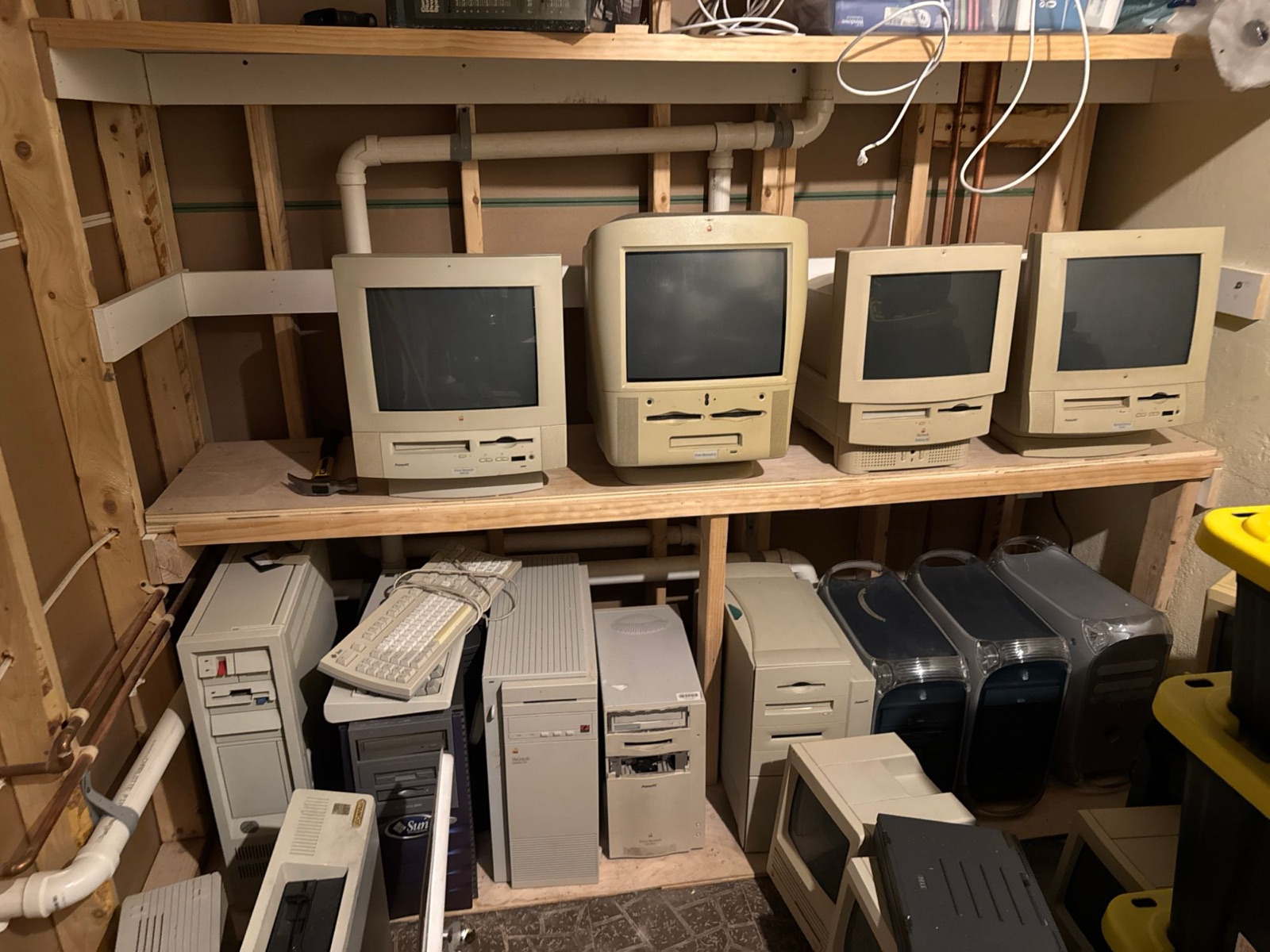 Storage shelves with all-in-one Macintosh computers above a row of tower systems