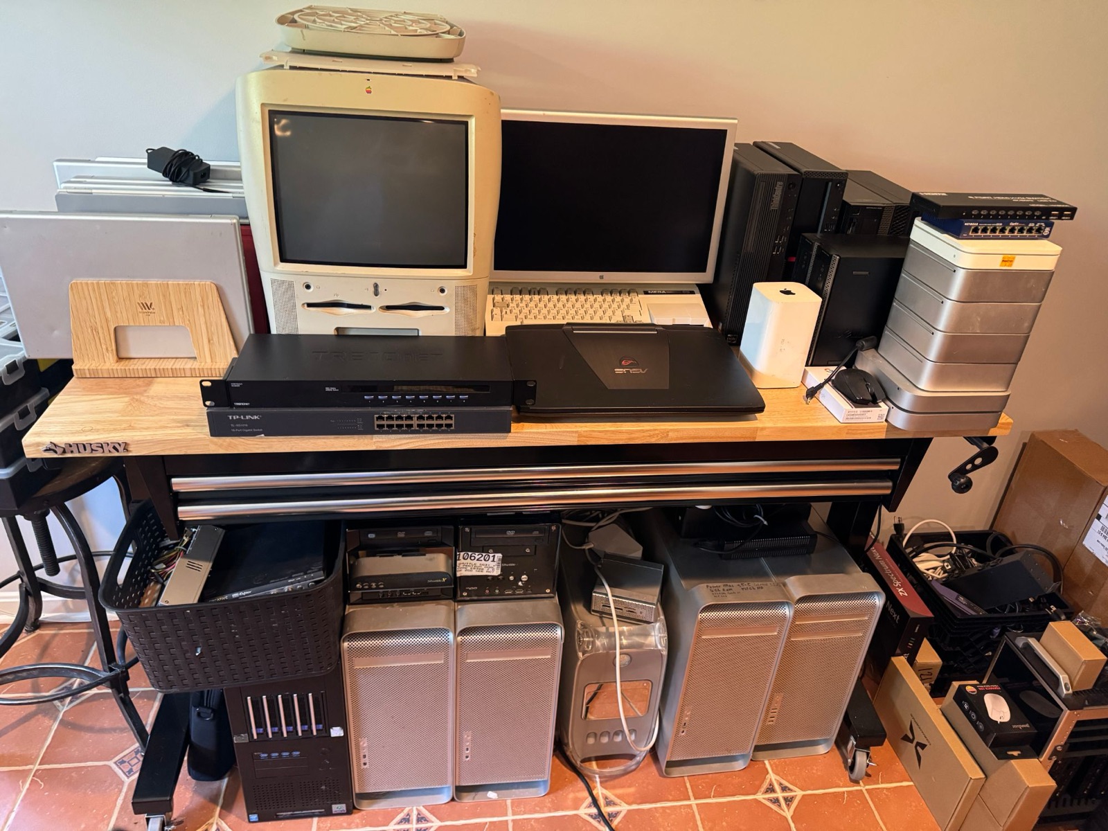 Staging workbench with a Power Macintosh G3 all-in-one, laptops, rack-mount network switches, and Power Mac G5 towers below